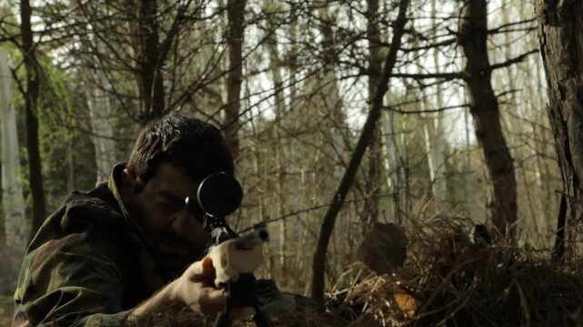 A focused sniper in camouflage uniform lies prone in a dense forest, aiming his rifle with precision while looking through the scope, ready for a crucial mission.