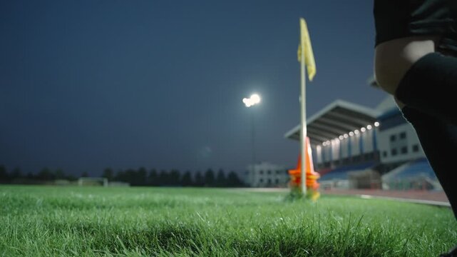A football boy drags a bag of balls to the stadium at night