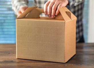 Male hand holding kraft takeaway gable box