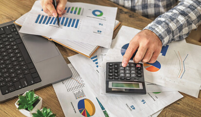 Businessman calculating budget with financial charts paperwork