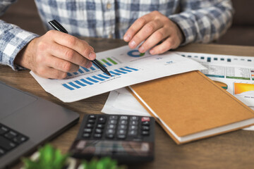 Businessman analyzing financial charts at office desk