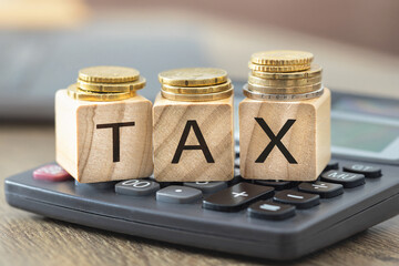 Tax concept with coins on calculator closeup