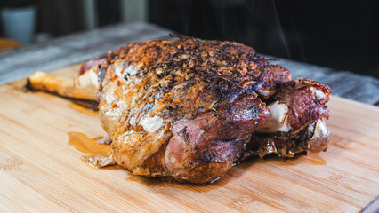 Whole roasted lamb leg with herb rub, golden brown crust, and aromatic seasoning on a wooden board. Juicy, tender, and ready to carve for a feast.