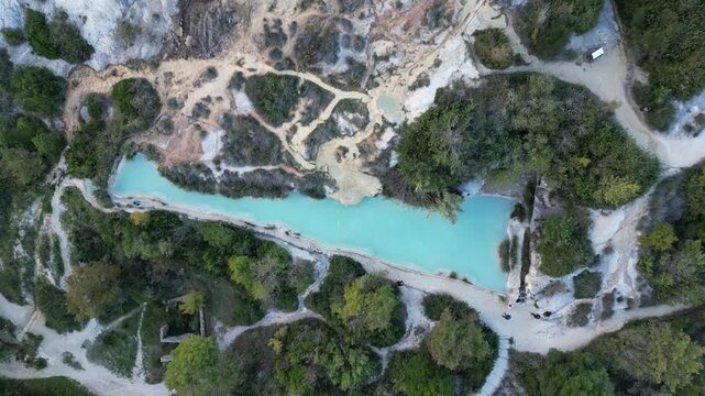 Aerial drone footage of the Antiche Terme Romane Libere, showcasing ancient Roman thermal ruins, natural pools, and the surrounding landscape. Captured from above with cinematic movement and clear arc