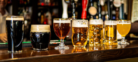 Seven Glasses of Beer with Different Shades and Styles