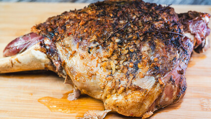 Whole roasted lamb leg with herb rub, golden brown crust, and aromatic seasoning on a wooden board. Juicy, tender, and ready to carve for a feast.