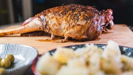 Whole roasted lamb leg with golden herb crust, served with cassava and olives. Juicy, tender, and ready to carve. A complete festive meal on a board.