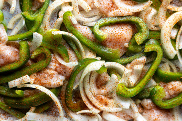 Sheet pan chicken fajitas with sliced onions, green bell peppers, and seasoned chicken arranged on a baking tray. Fresh, simple, and perfect for meal prep or easy dinner recipes.