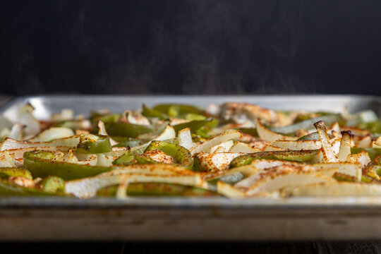 Sheet pan chicken fajitas with sliced onions, green bell peppers, and seasoned chicken arranged on a baking tray. Fresh, simple, and perfect for meal prep or easy dinner recipes. - Powered by Adobe