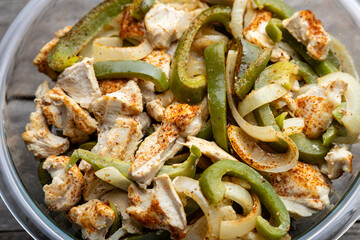 Sheet pan chicken fajitas with sliced onions, green bell peppers, and seasoned chicken arranged on a baking tray. Fresh, simple, and perfect for meal prep or easy dinner recipes.