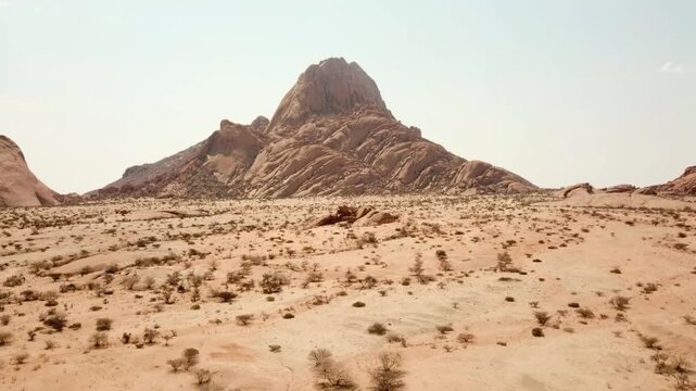 Aerial drone footage of Spitzkoppe, a massive granite inselberg rising from the Namib Desert in Namibia. Scenic rocky landscape, desert terrain, and dramatic geological formations captured in UHD 4K.