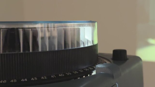 Vintage carousel slide projector running in a dark room with sound, rotating slide tray, warm light beam and changing photos creating a nostalgic analog presentation atmosphere.