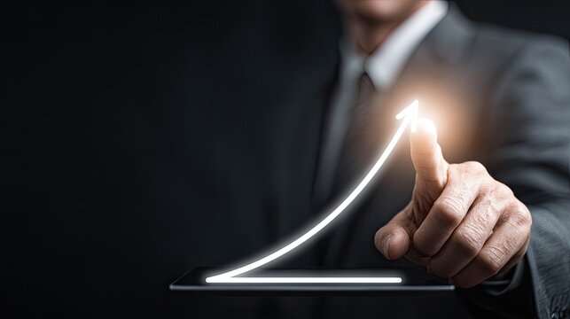 Businessman interacts with glowing upward trending arrow graphic emerging from a digital surface - Powered by Adobe