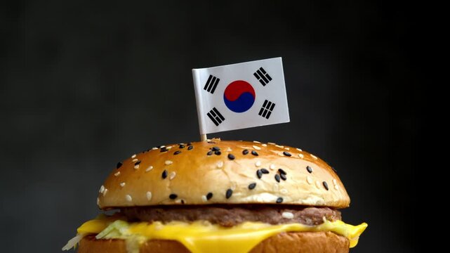 Close up burger with South Korean flag, scene points to local Korean meat, sauces and food technology used for burger.
