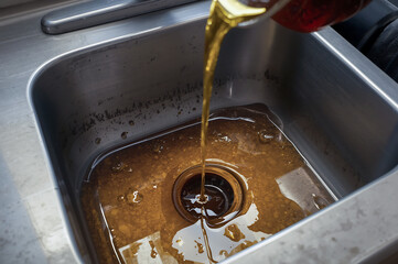 Dark cooking oil pouring into kitchen sink causing severe clog
