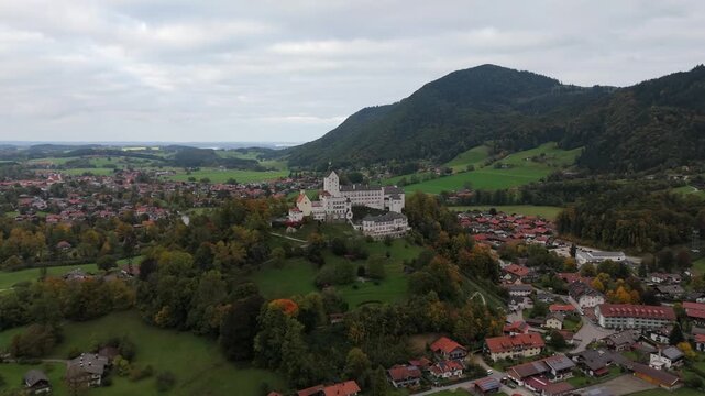 Aerial video of Schloss Hohenaschau in Aschau im Chiemgau, Bavaria, Germany, surrounded by colorful autumn forest and fog over the Priental valley.