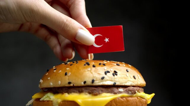 Close up burger with Turkish flag, frame associates sandwich with Turkish halal meat industry and local bread baking.