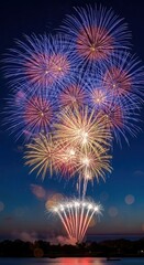 Vibrant fireworks explode over dark lake at night