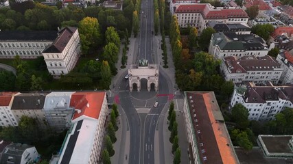 Aerial summer view of Munich at sunrise, featuring the iconic Siegestor triumphal arch, Bavaria statue with lions, Ludwigstrasse, and Leopoldstrasse, perfect for travel and architectural video content