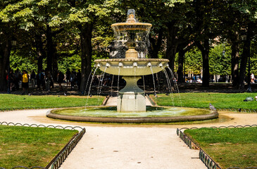 Fountain at the center Place des Vosges in the Marais district during a summer day, one of the oldest and most beautiful squares in Paris, France