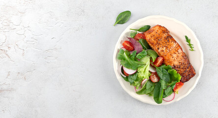 Grilled salmon fillet with fresh green salad, cherry tomatoes, radish. Healthy low-carb meal. Top view. Copy space.