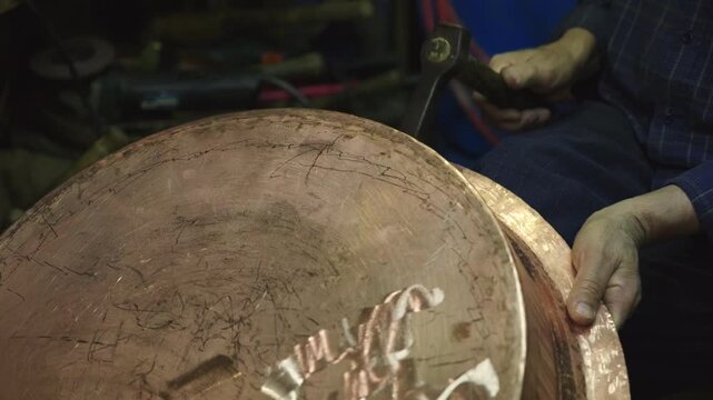 Turkish craftsman hammering a traditional copper cauldron