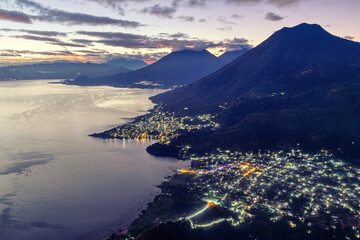 Lake Atitlan and its three volcanoes on a dramatic sunrise, Guatemala