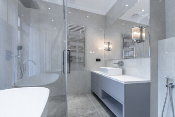 The bathroom has a modern design, elegant decor in bright colors. Large windows let in natural light, emphasizing the elegant modern plumbing.