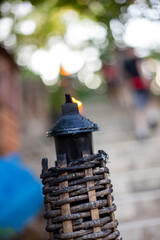 A lit tiki torch in a Mexican cemetery.