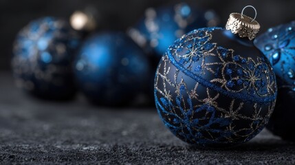 A collection of elegant blue and silver Christmas ornaments is showcased on a textured dark surface capturing the festive spirit and holiday cheer.