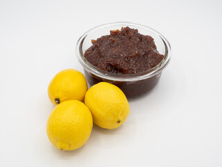 High angle shot of indian lemon pickle with three fresh lemons