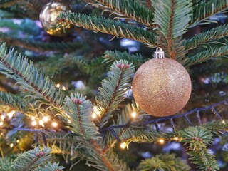 Goldene Weihnachtskugel am Tannenbaum im Freien