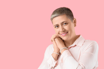 Young woman with short hair in shirt on pink background
