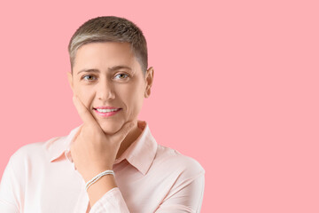 Thoughtful young woman with short hair in shirt on pink background, closeup