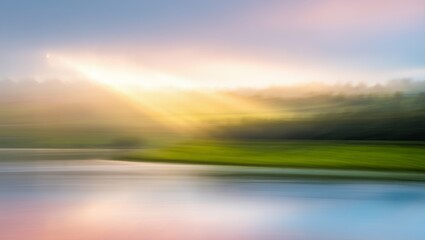 Fototapeta premium Abstract landscape with blurred green fields, calm water, and radiant sunlight breaking through the clouds