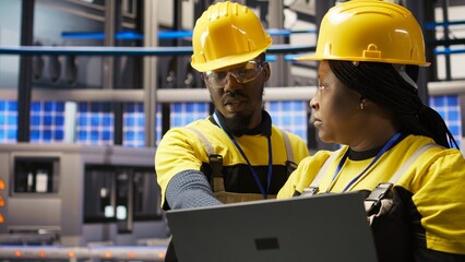 Fototapeta premium Engineering team working together, overseeing solar panel production lines equipment. Teamworking colleagues maintaining photovoltaic assembly systems in automated industry 4.0 factory, camera A