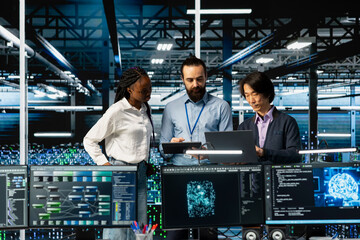 Team of data center coworkers in office running AI forecasting simulations, tracking performance. Teamworking server hub colleagues using PC to integrate deep learning APIs into software platforms
