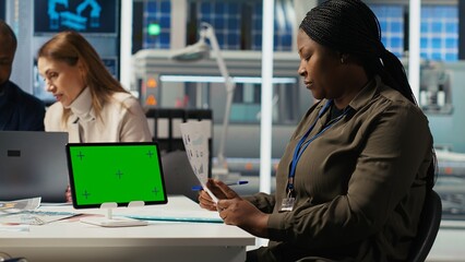 Factory engineer tripping while study assembly lines schematics, refining production layouts using green screen tablet. Experts outlining industrial plant configurations using mockup device, camera B
