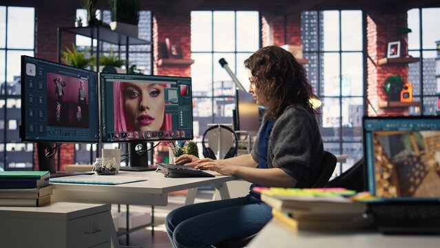 Woman expert developer works with photo editing software in the creative workspace, digital media. Using dual monitors to ensure productivity and innovation in the graphic design world. Camera A. - Powered by Adobe