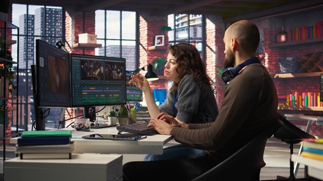 Creative couple working together on video editing software for movie making, using AI powered models and prompts to create the perfect montage. Editors team in post production. Camera A.