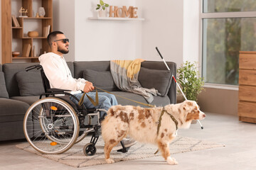 Blind young man in wheelchair with guide dog at home
