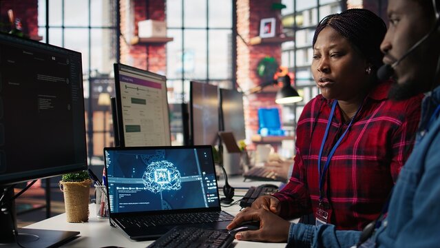 Call center coworkers in office helping customers regain access to accounts using AI, resetting passwords. Colleagues in customer center assisting clients needing help using artificial intelligence