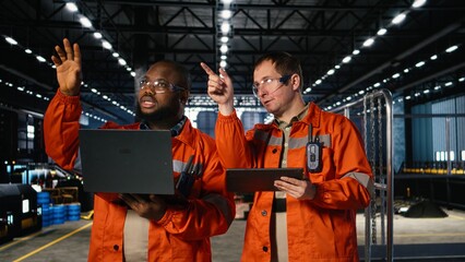 Colleagues use laptop and tablet to guide personnel during fabrication and production tasks, highlighting industrial labor and engineering. Operation of the manufacturing process.