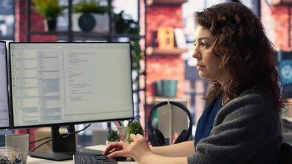 Female programmer developing app and software algorithm on pc, working at creative agency. Engineer uses digital tools and focuses on java script engineering and coding, IT specialist. Camera B.