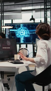 Vertical video Inexperienced intern in office requests help from team to fix hacking attempt on corporate network. Coworkers investigate unauthorized access alerts, brainstorming ways to mitigate