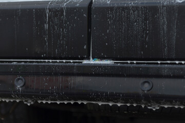 Flowing water reveals bumper textures, Stream of water uncovers seam and runoff details, Flowing streams illustrate bumper seam features and runoff markings in detailed water movement