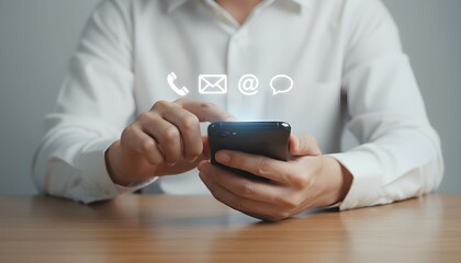 A person in a white shirt using a smartphone with communication icons floating above it.