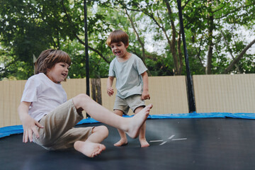 Happy boys playing on a trampoline outdoors, enjoying a sunny day with laughter and joy. Their playful spirits shine through in this delightful scene.