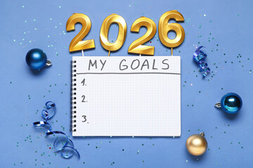 Notebook with to-do list, candles in shape of figure 2026 and Christmas decor on blue background
