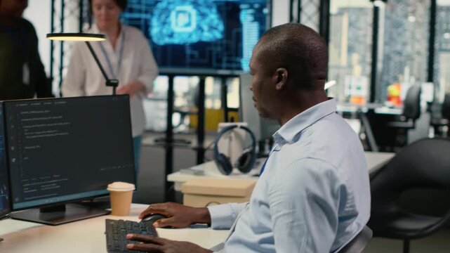 Data scientist in office automating workflows using artificial intelligence on PC. IT professional refines deep learning computational models on computer for faster processing, camera B